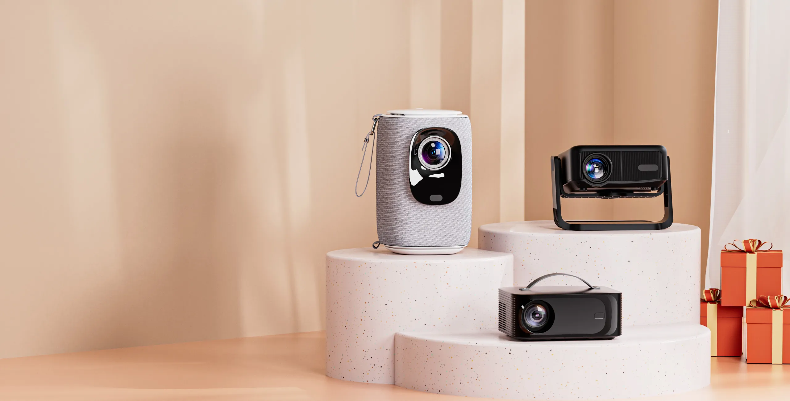 Three ONOAYO projectors arranged on terrazzo pedestals against a warm beige studio backdrop, with gift boxes stacked at the right